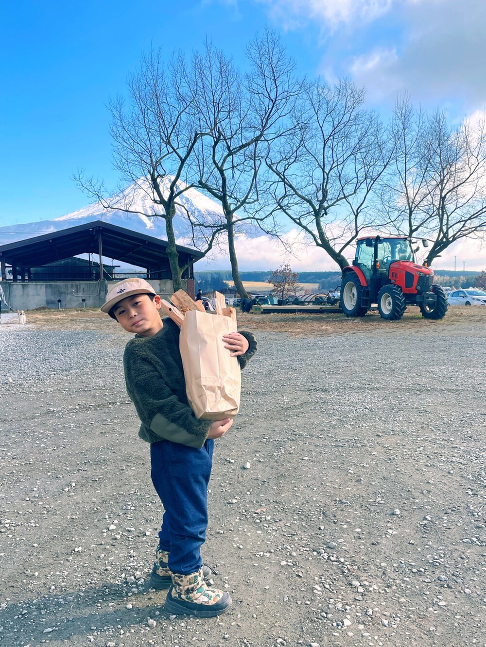 グリーン系のトップス、ブルー系のパンツ、ベージュ系のブーツを着用したキッズの冬コーディネートの2枚目の写真