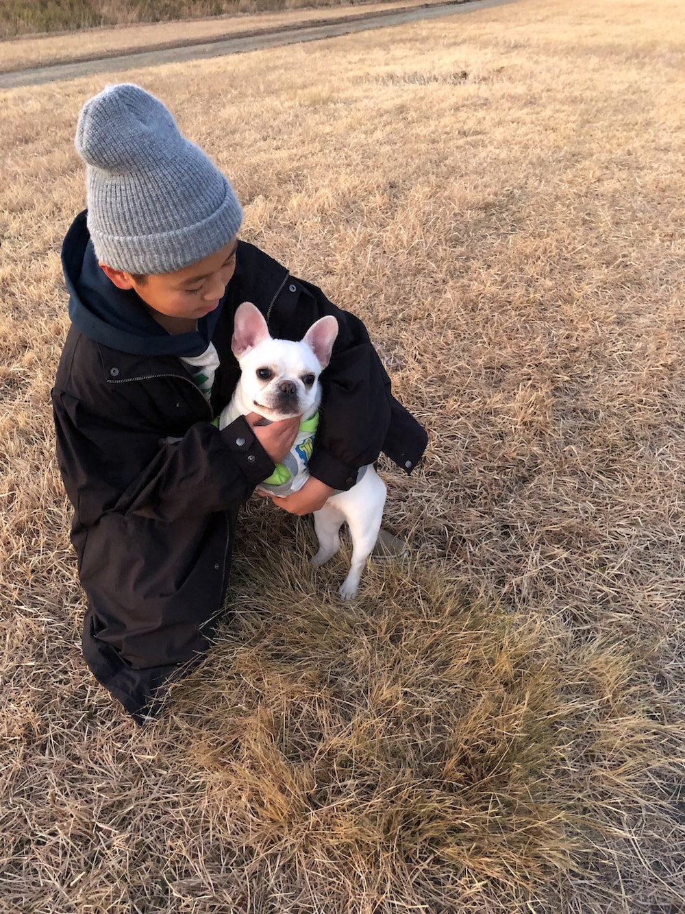 ブラック系のモッズコート、ホワイト系のパーカー、グリーン系のその他パンツを着用したキッズの冬コーディネートの4枚目の写真