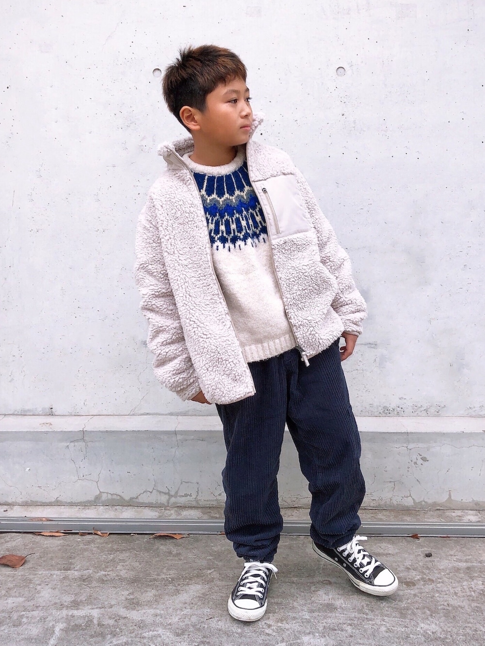 ホワイト系のジャケット/アウター、ホワイト系のニット/セーター、ブルー系のパンツを着用したキッズの冬コーディネートの2枚目の写真