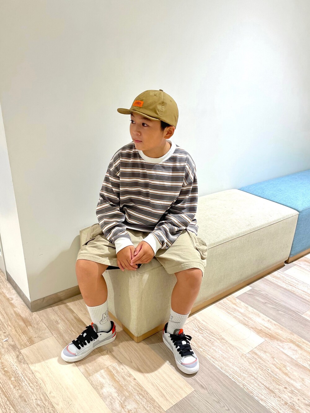 ベージュ系のTシャツ/カットソー、ベージュ系のカーゴパンツ、ホワイト系のスニーカーを着用したキッズの秋コーディネートの3枚目の写真