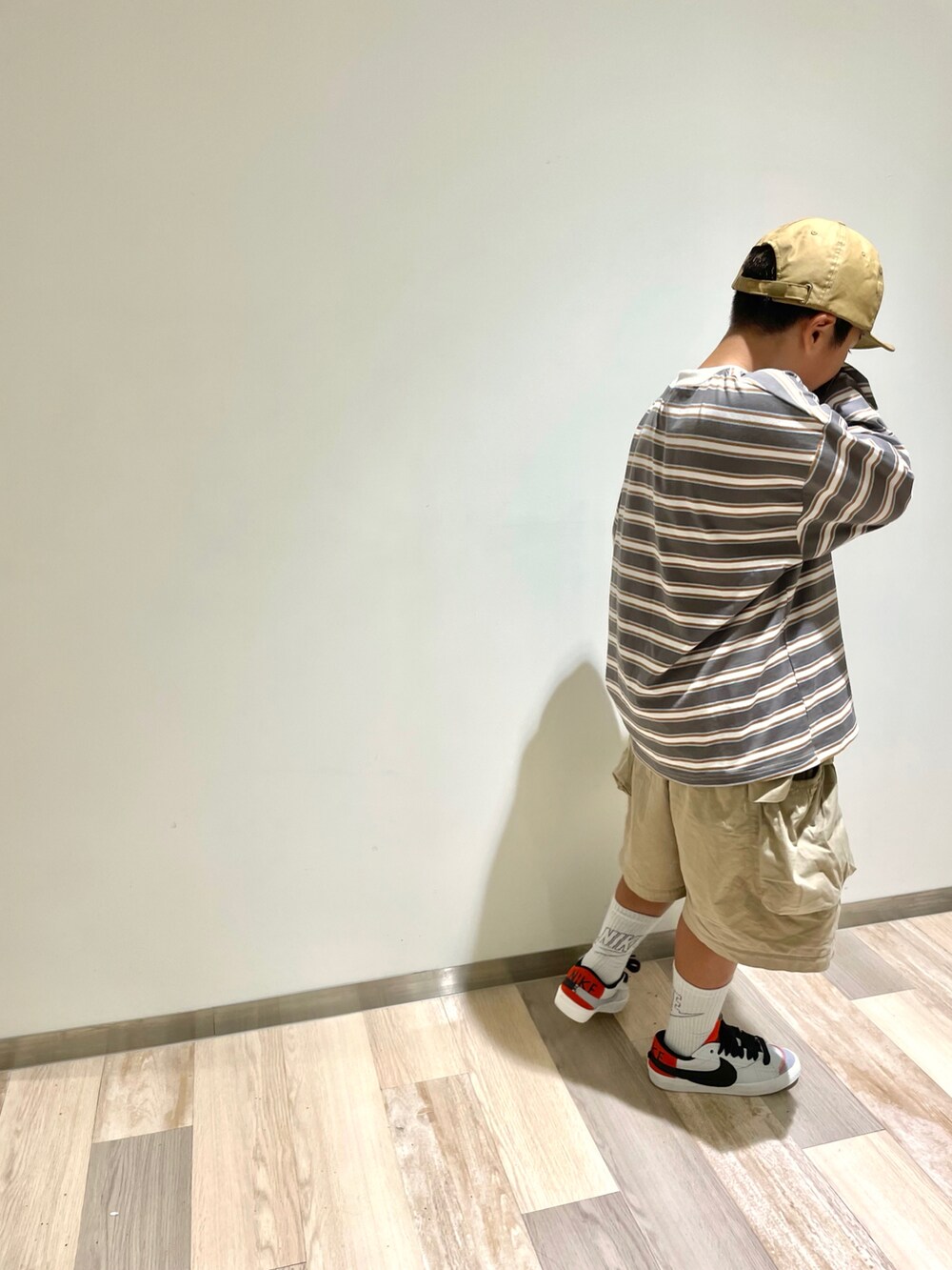 ベージュ系のTシャツ/カットソー、ベージュ系のカーゴパンツ、ホワイト系のスニーカーを着用したキッズの秋コーディネートの2枚目の写真