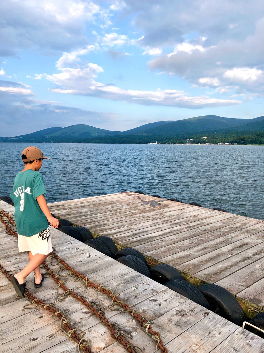 グリーン系のTシャツ/カットソー、ホワイト系のパンツ、ブラック系のサンダルを着用したキッズの夏コーディネートの2枚目の写真