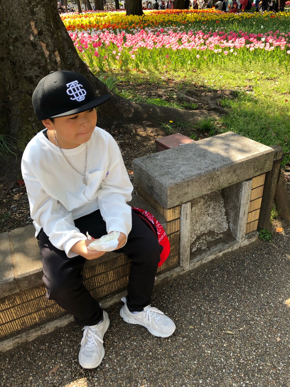 ホワイト系のTシャツ/カットソー、ブラック系のその他パンツ、グレー系のスニーカーを着用したキッズの春コーディネートの2枚目の写真