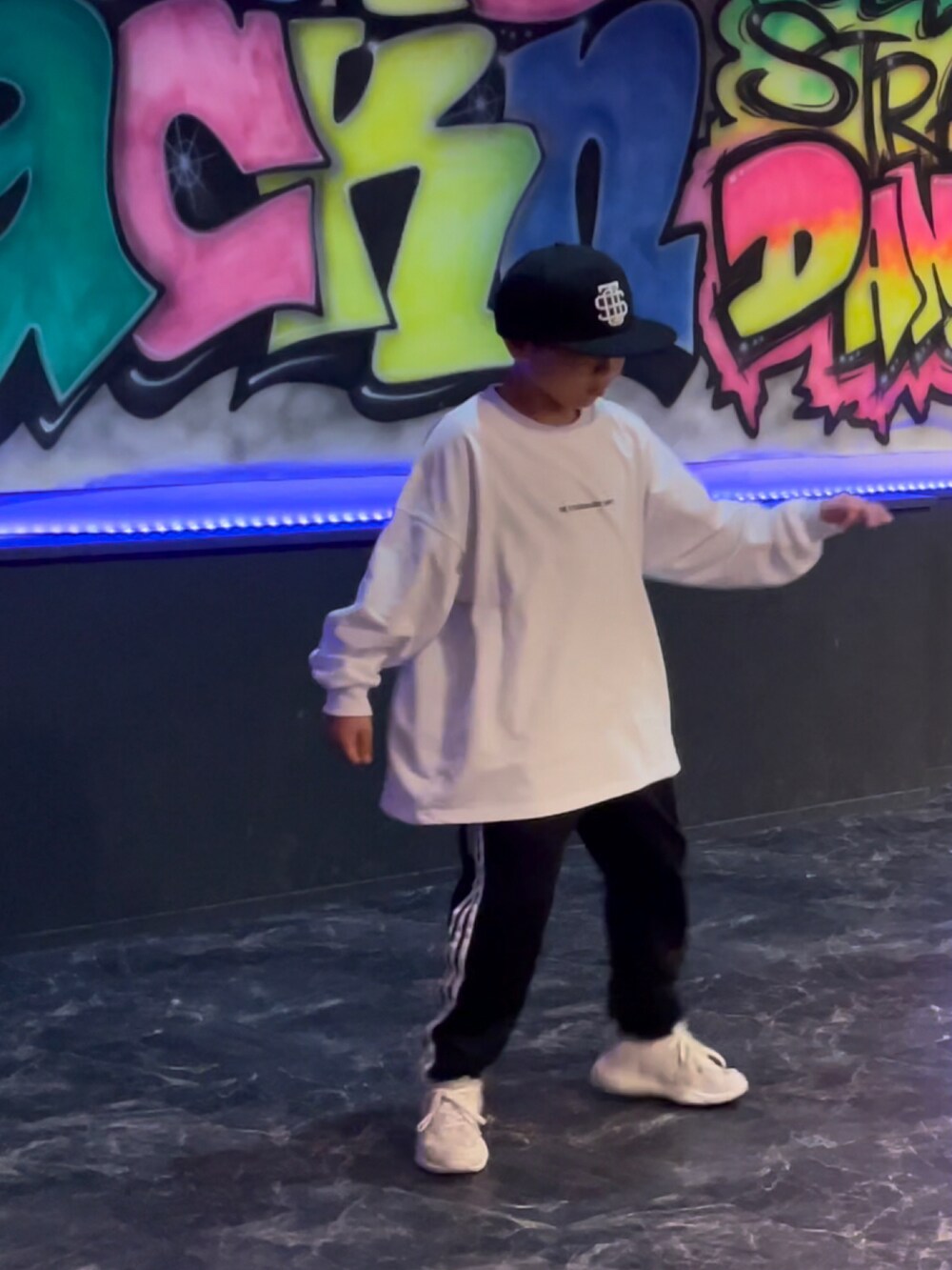 ホワイト系のTシャツ/カットソー、ブラック系のスウェットパンツ、イエロー系のスニーカーを着用したキッズの春コーディネートの3枚目の写真