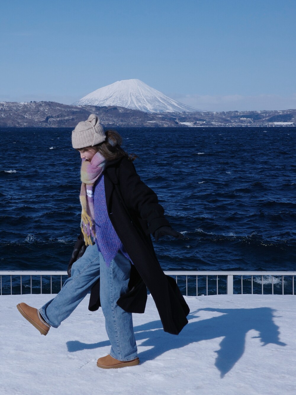 パープル系のニット/セーター、ブラック系のチェスターコート、ブラウン系のスリッポンを着用したレディースの冬コーディネートの3枚目の写真