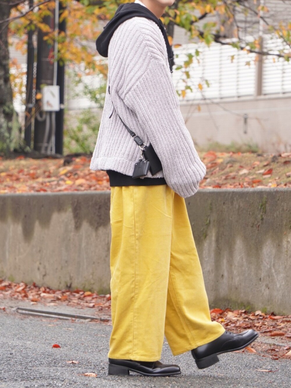 グレー系のニット/セーター、ブラック系のパーカー、イエロー系のその他パンツを着用したメンズの冬コーディネートの2枚目の写真