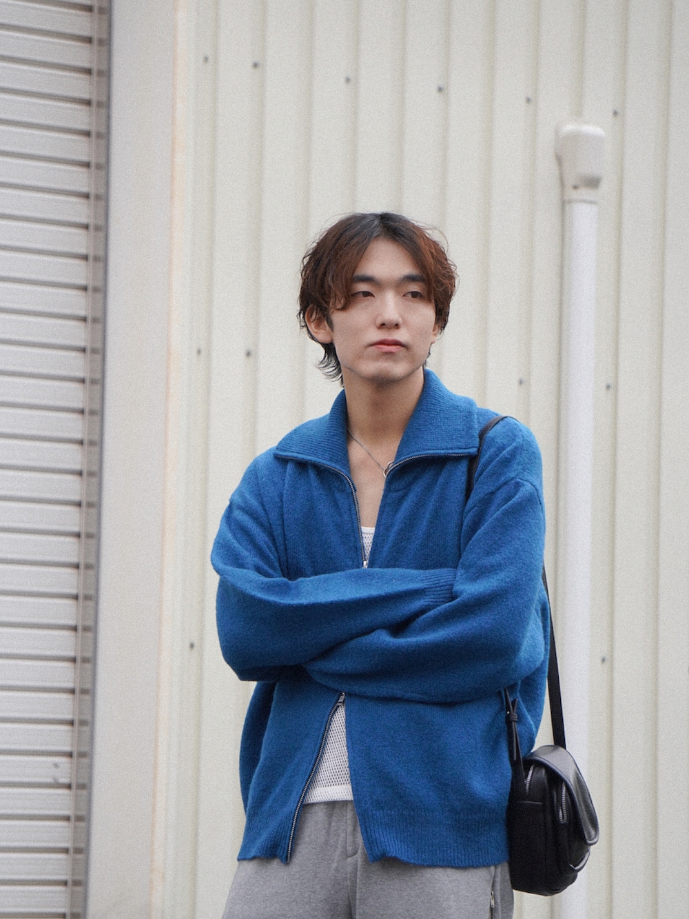 ブルー系のニット/セーター、ホワイト系のタンクトップ、グレー系のスウェットパンツを着用したメンズの秋コーディネートの5枚目の写真