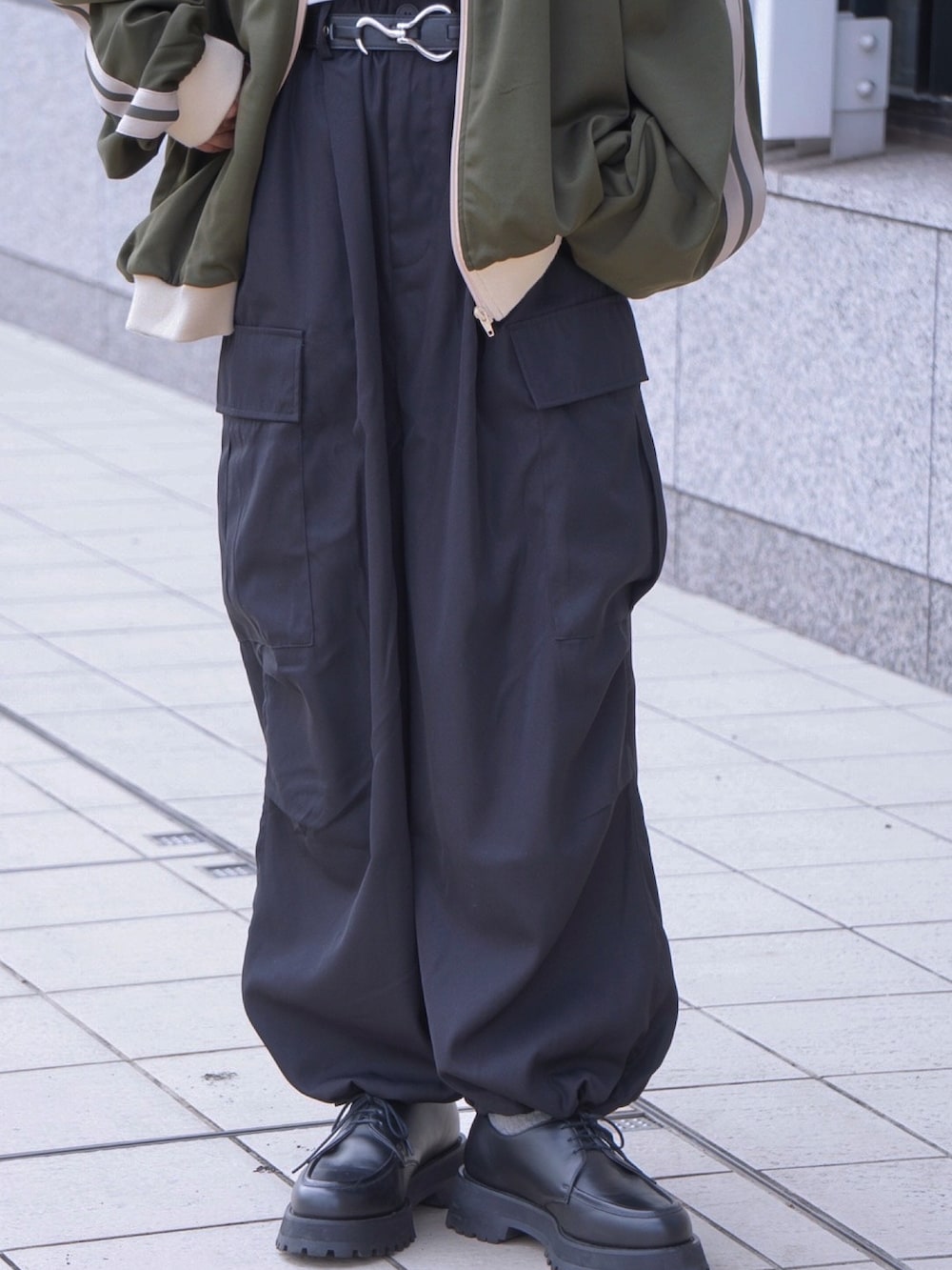 ブラック系のカーゴパンツ、グリーン系のブルゾン、ブラック系のドレスシューズを着用したメンズの秋コーディネートの5枚目の写真