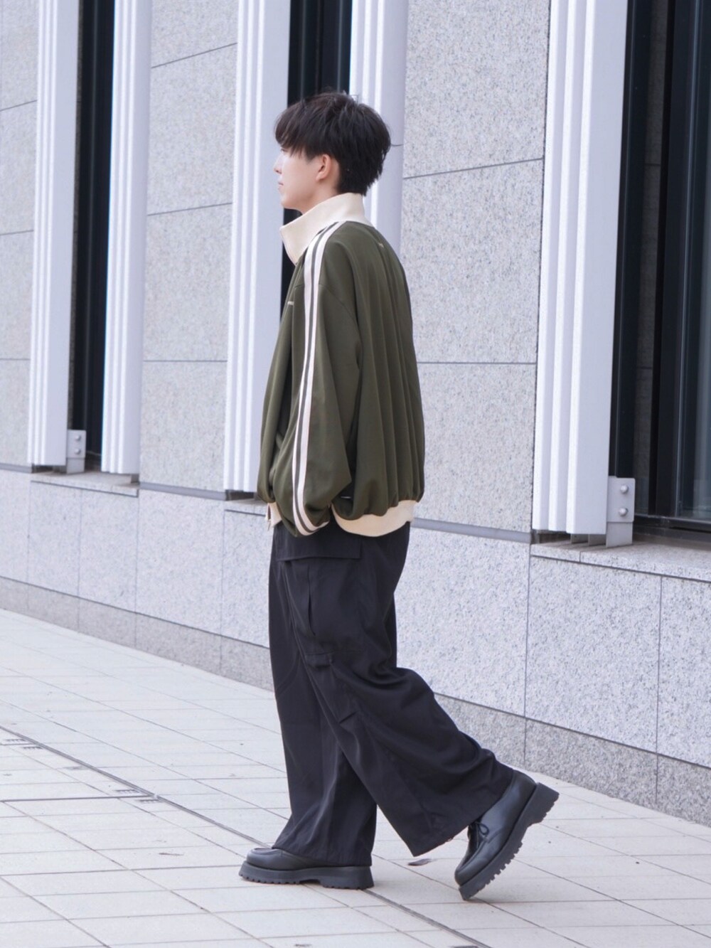ブラック系のカーゴパンツ、グリーン系のブルゾン、ブラック系のドレスシューズを着用したメンズの秋コーディネートの2枚目の写真