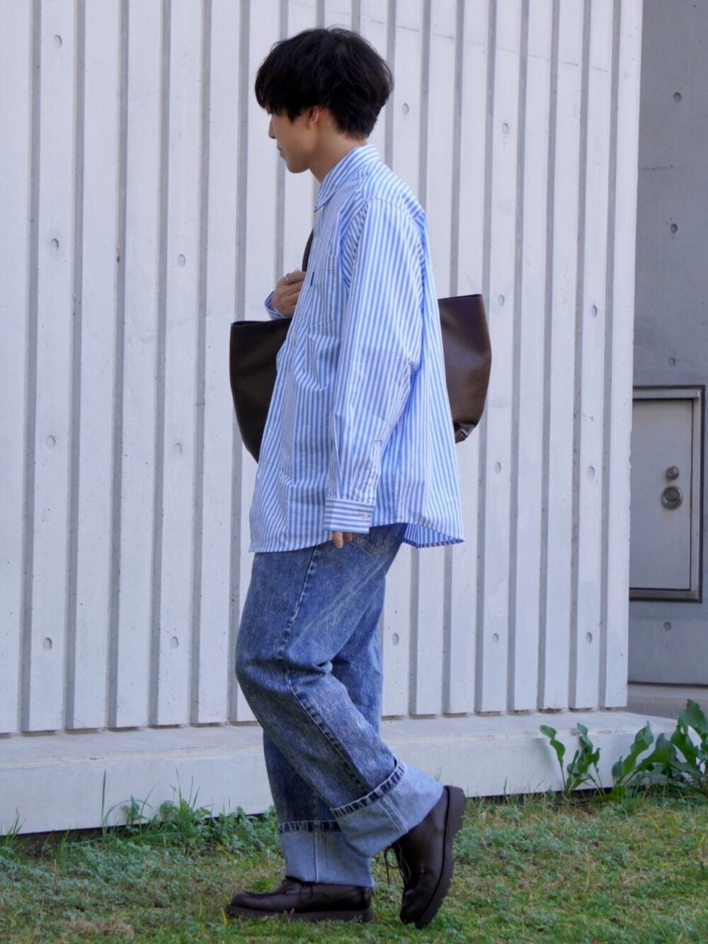 ブルー系のシャツ/ブラウス、ブルー系のデニムパンツ、ブラウン系のトートバッグを着用したメンズの春コーディネートの2枚目の写真