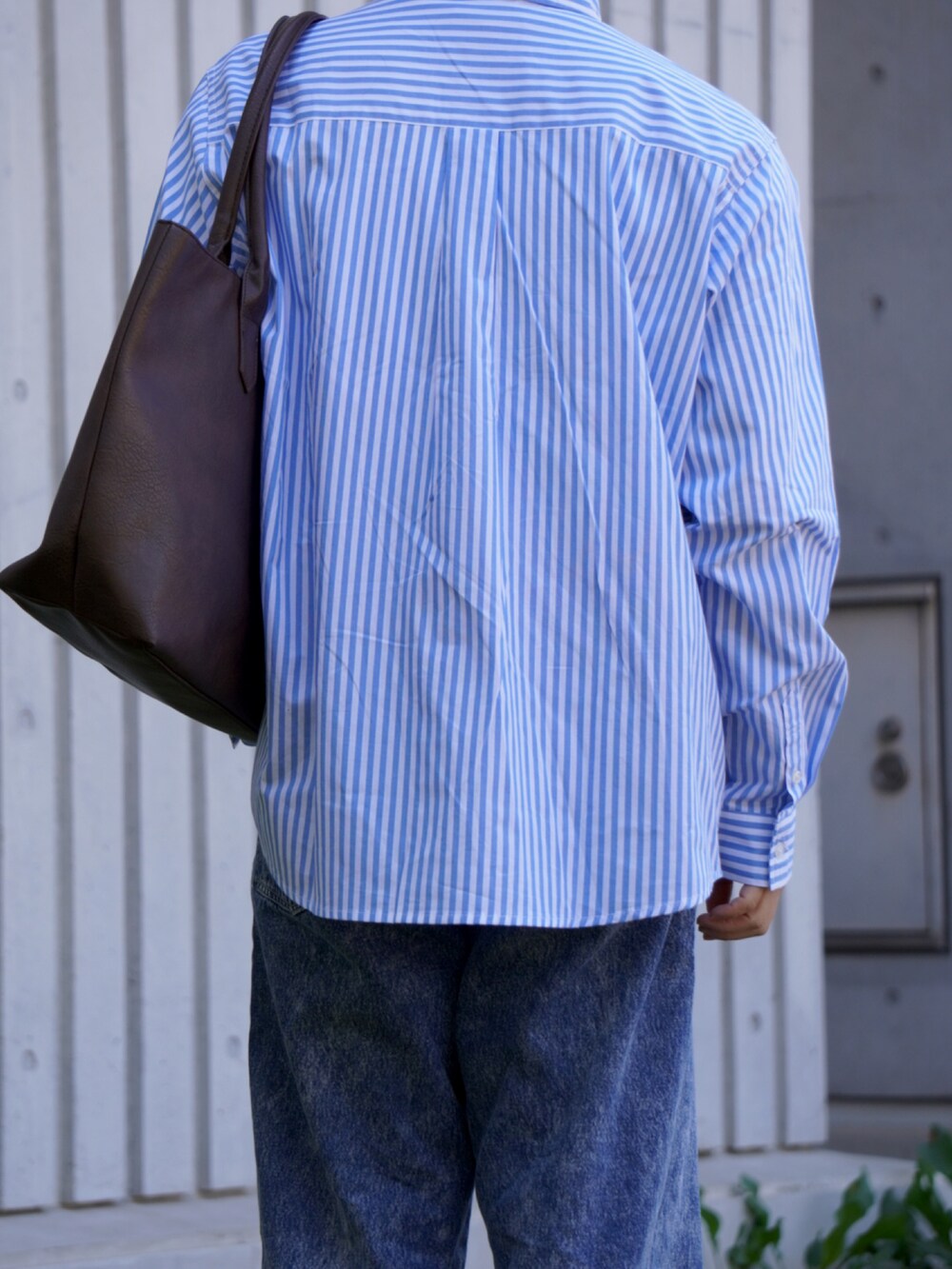 ブルー系のシャツ/ブラウス、ブルー系のデニムパンツ、ブラウン系のトートバッグを着用したメンズの春コーディネートの5枚目の写真