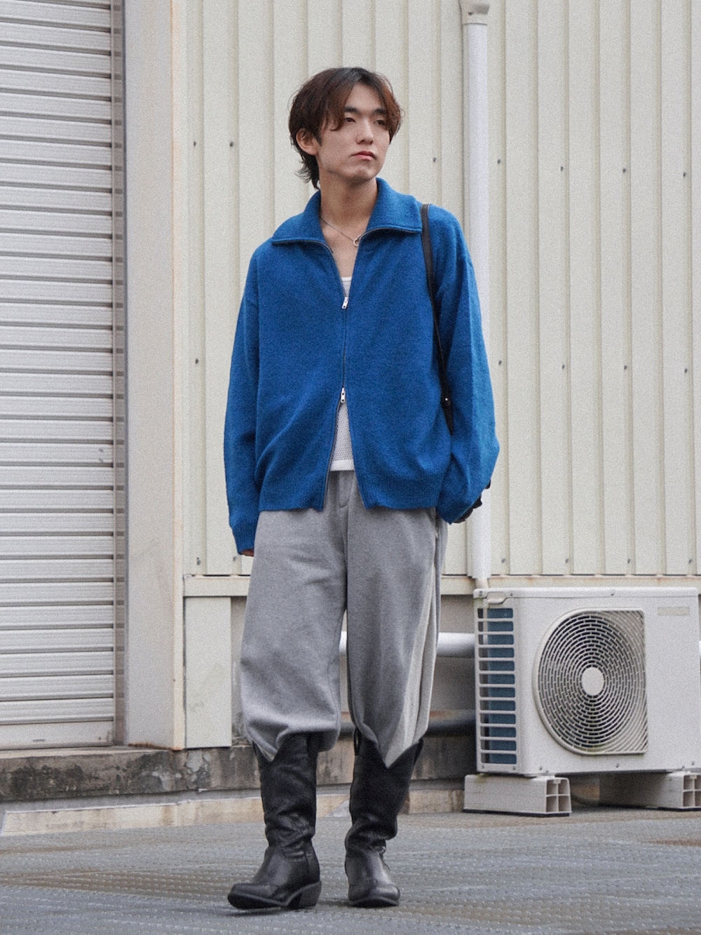 ブルー系のニット/セーター、ホワイト系のタンクトップ、グレー系のスウェットパンツを着用したメンズの秋コーディネートの3枚目の写真