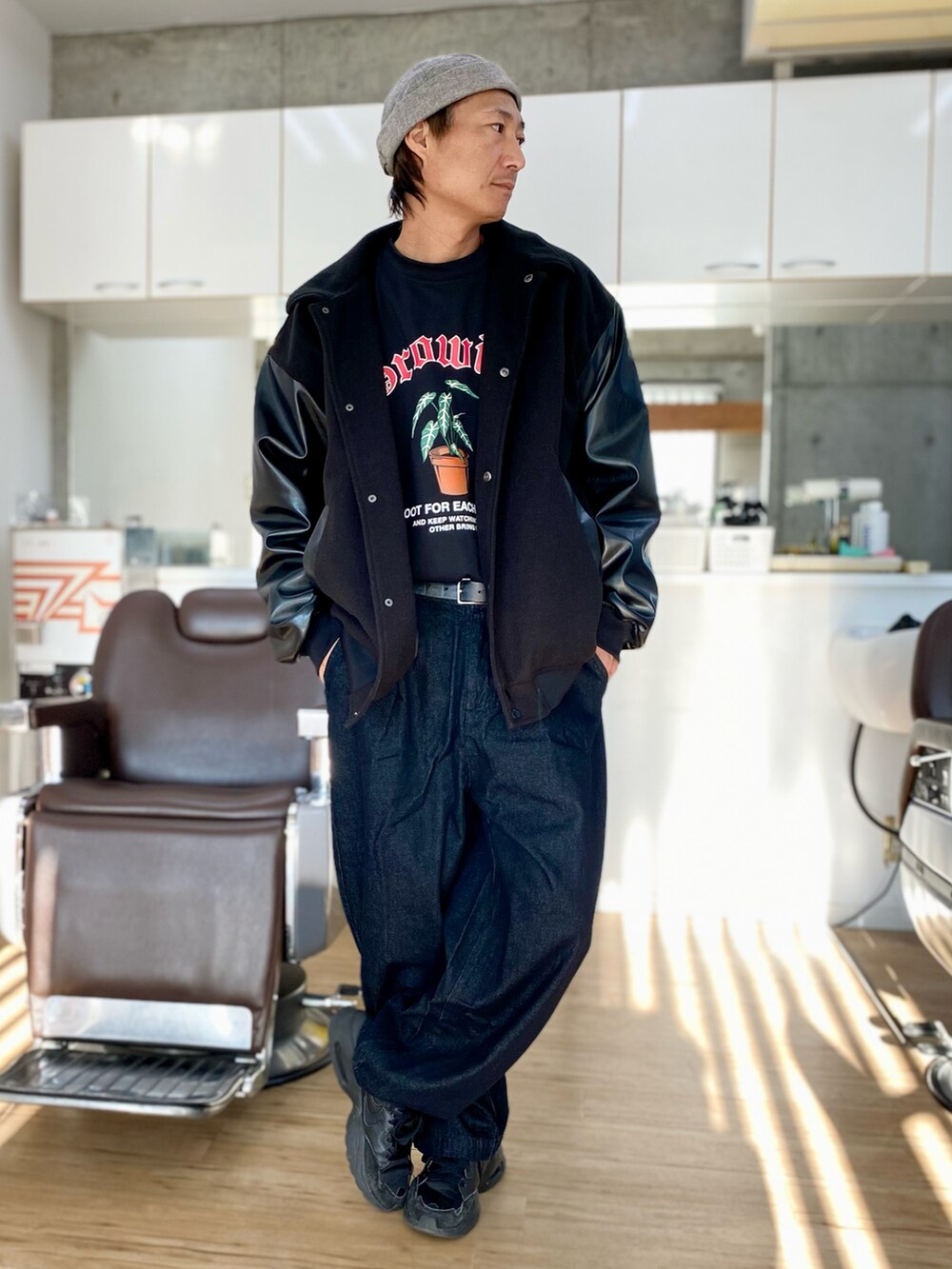 ブラック系のデニムパンツ、ブラック系のスニーカー、ブラック系のTシャツ/カットソーを着用したメンズの冬コーディネートの2枚目の写真