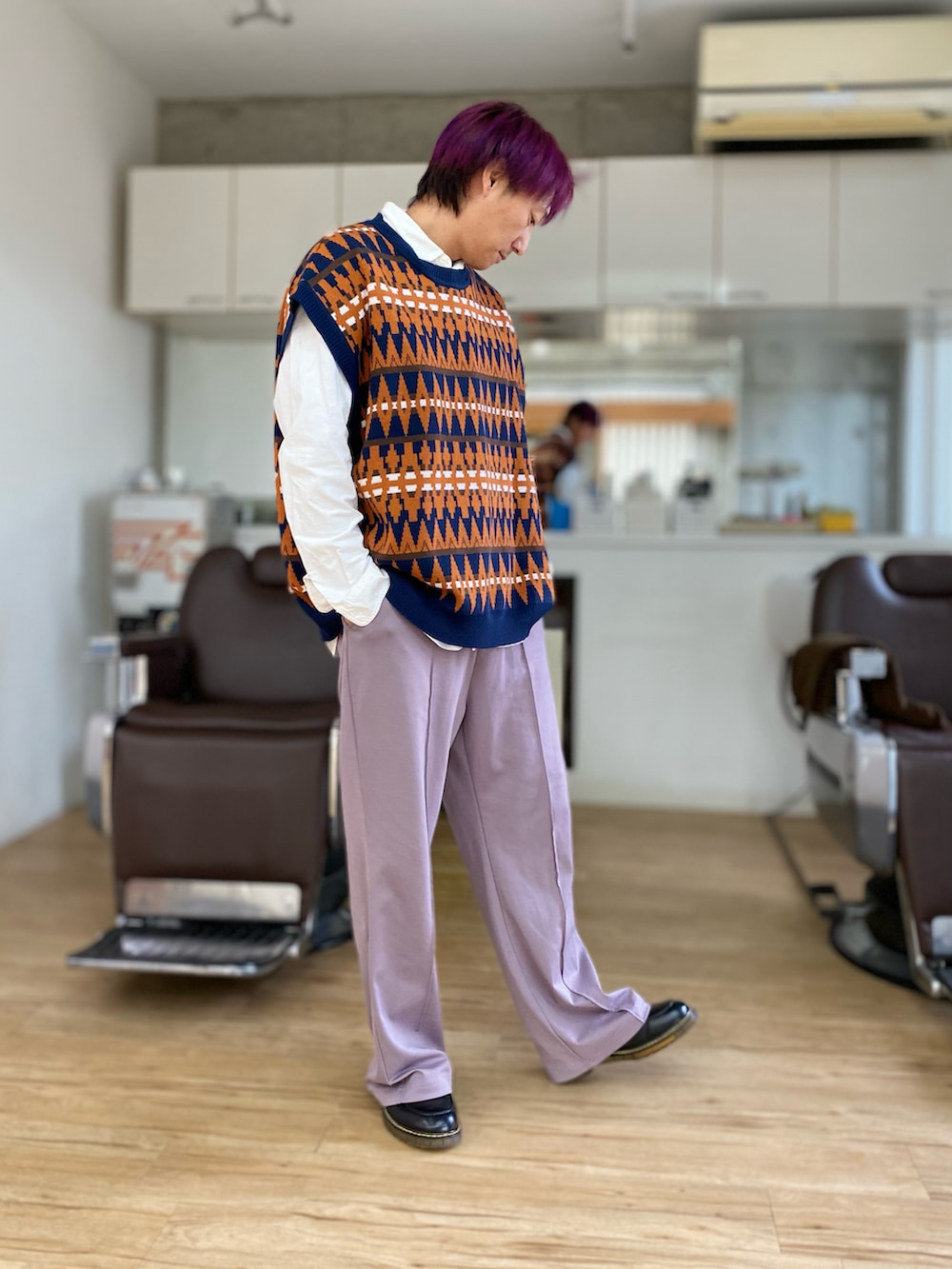 パープル系のスラックス、ブラック系のスニーカー、ブルー系のベストを着用したメンズの冬コーディネートの2枚目の写真