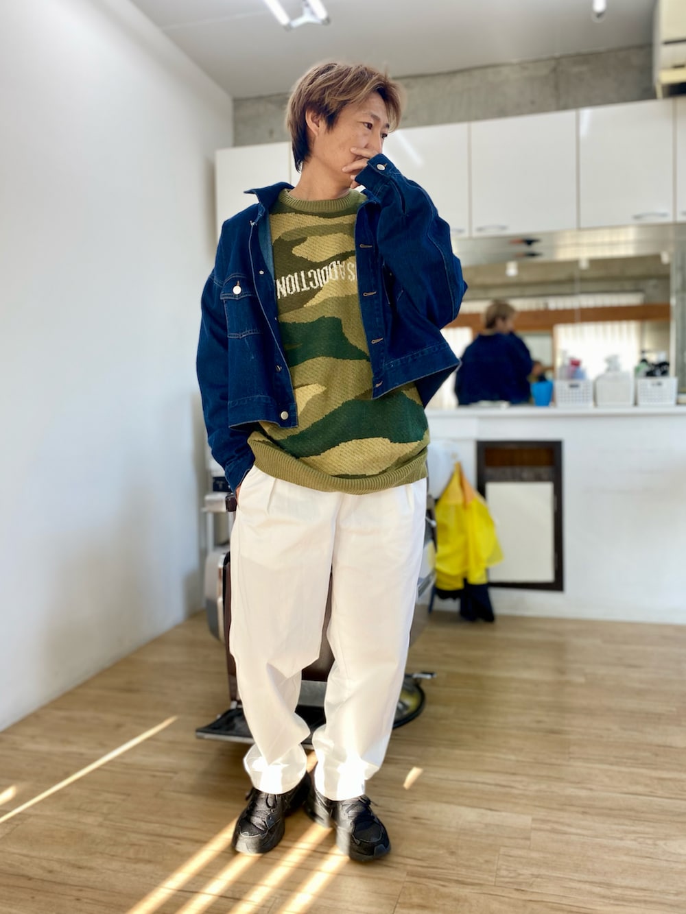 ホワイト系のチノパンツ、グリーン系のニット/セーター、ブルー系のデニムジャケットを着用したメンズの冬コーディネートの2枚目の写真