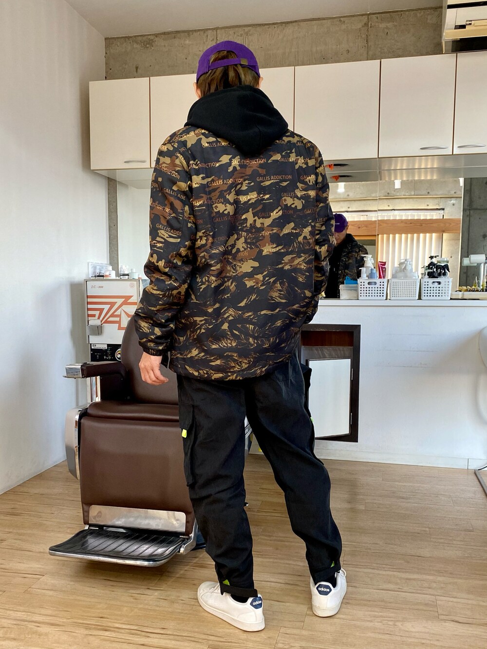 ブラック系のカーゴパンツ、ホワイト系のスニーカー、ブラック系のパーカーを着用したメンズの冬コーディネートの2枚目の写真