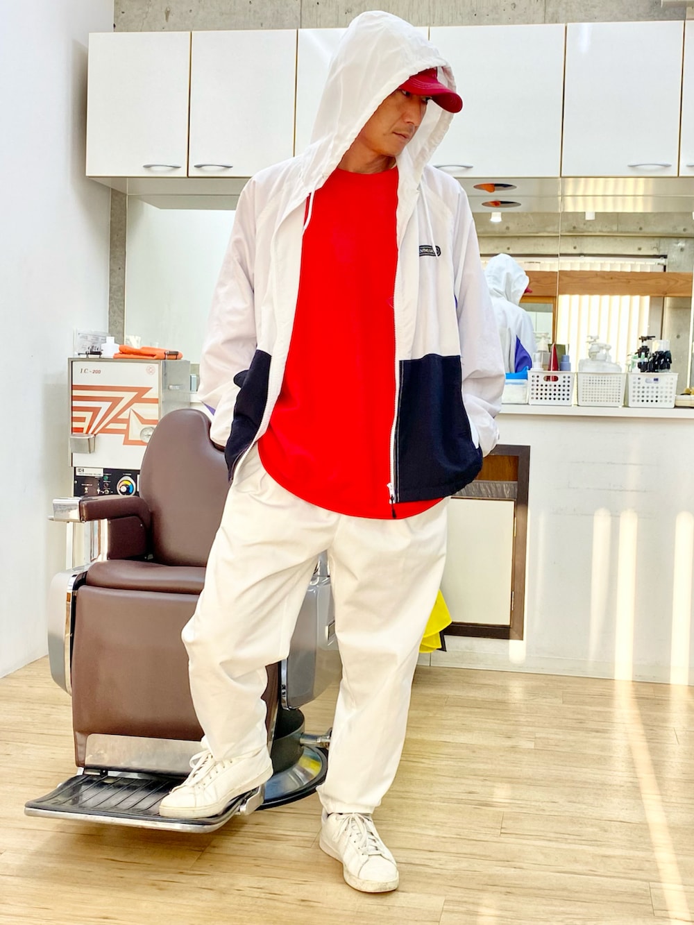 ホワイト系のチノパンツ、ホワイト系のスニーカー、ホワイト系のナイロンジャケットを着用したメンズの冬コーディネートの3枚目の写真