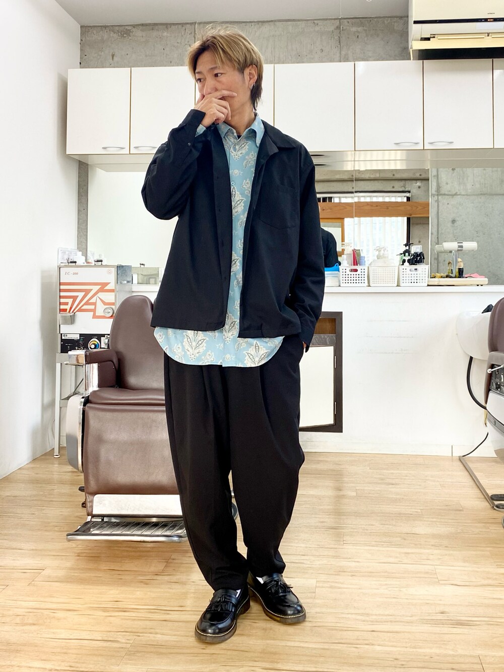 ブラック系のその他パンツ、ブラック系のローファー、グレー系のチェスターコートを着用したメンズの冬コーディネートの2枚目の写真