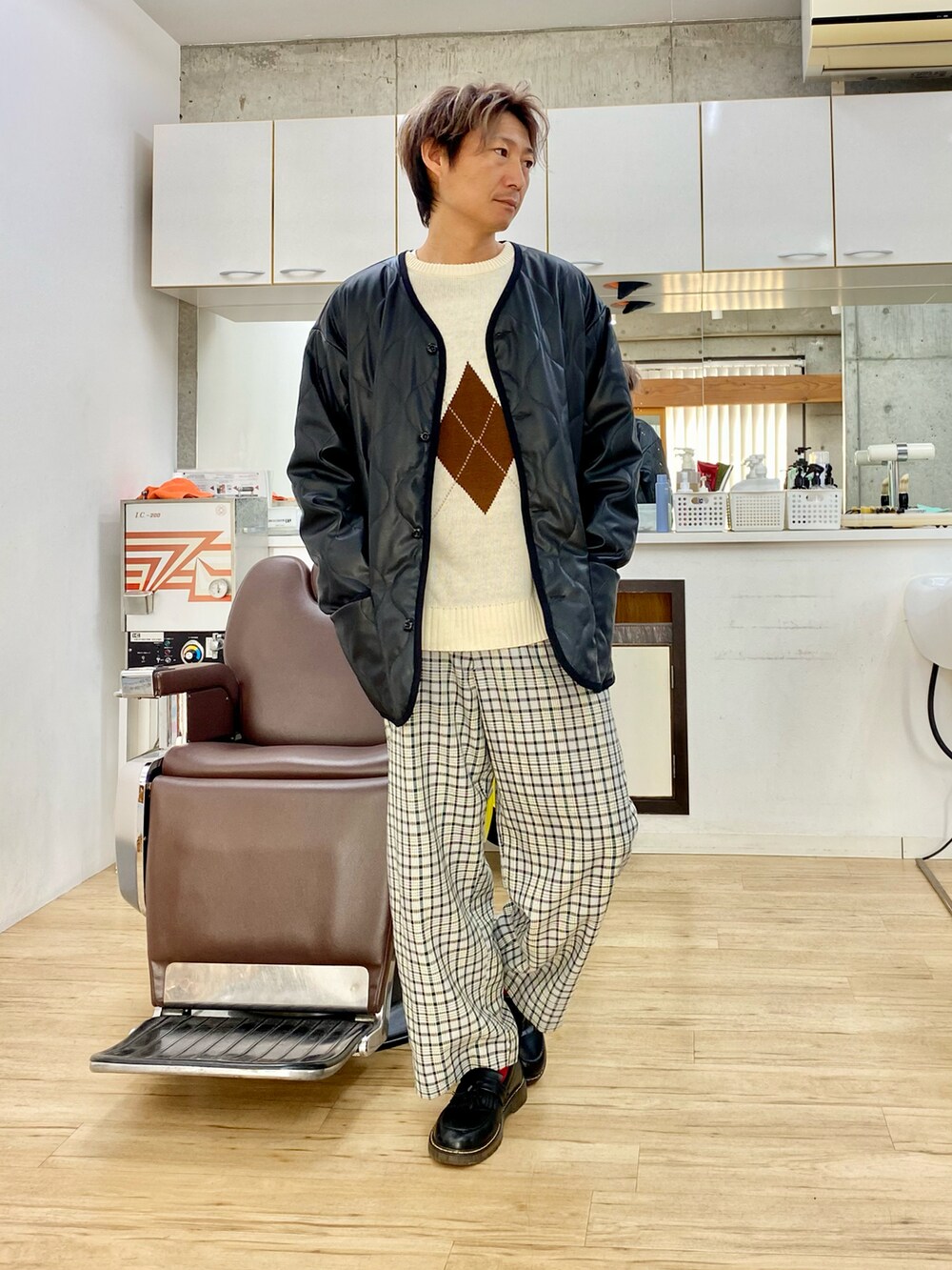 ブラック系のダウンジャケット/コート、ブルー系のスラックス、ブラック系のローファーを着用したメンズの冬コーディネートの3枚目の写真