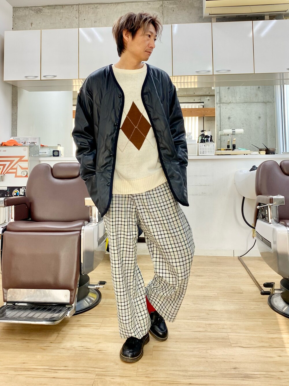 ブラック系のダウンジャケット/コート、ブルー系のスラックス、ブラック系のローファーを着用したメンズの冬コーディネートの2枚目の写真