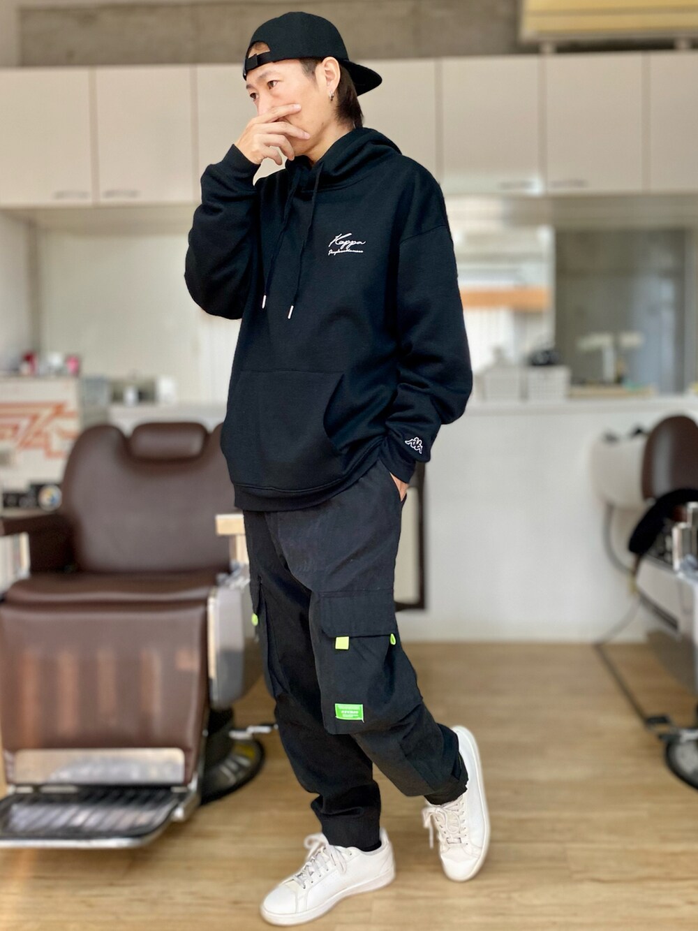 ブラック系のカーゴパンツ、ホワイト系のスニーカー、ブラック系のパーカーを着用したメンズの冬コーディネートの2枚目の写真