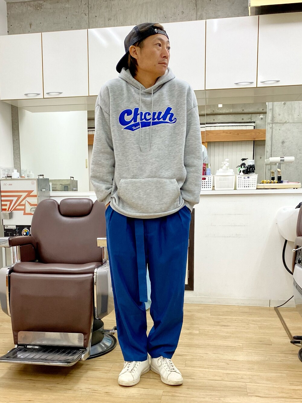 「大人コーデ、ストリート、パーカー、オーバーサイズ、カラーパンツ、グレー、ブルー、キャップ、スニーカー、スタジャン」｜「BenoのP/ライトツイル ベルト付き タックワイド テーパードパンツ（その他パンツ、ブルー系）」を使った、チョキさんさん（メンズ・170cm）の冬コーディネートの2枚目の写真