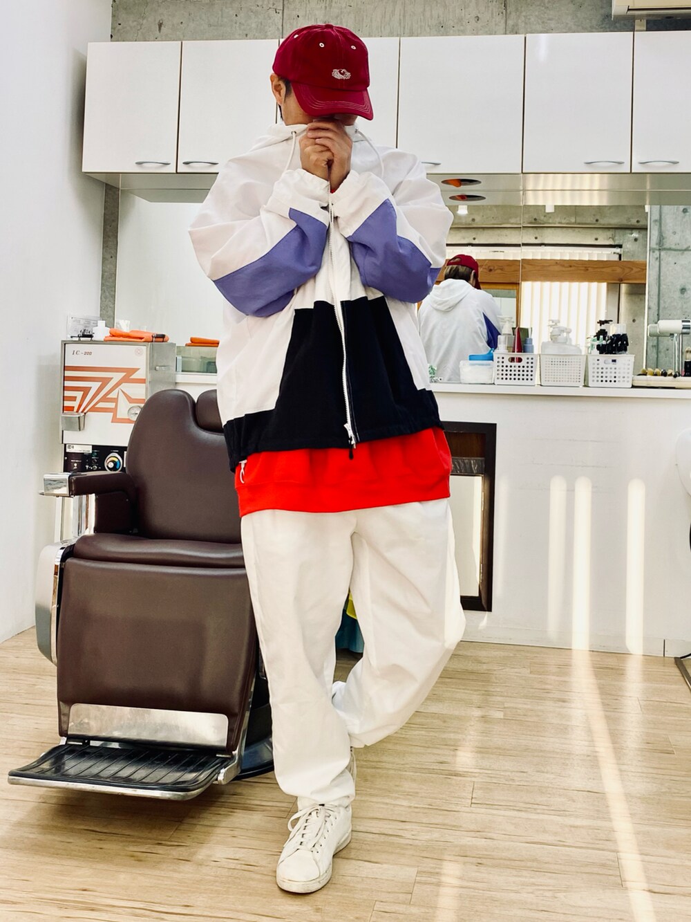 ホワイト系のチノパンツ、ホワイト系のスニーカー、ホワイト系のナイロンジャケットを着用したメンズの冬コーディネートの2枚目の写真