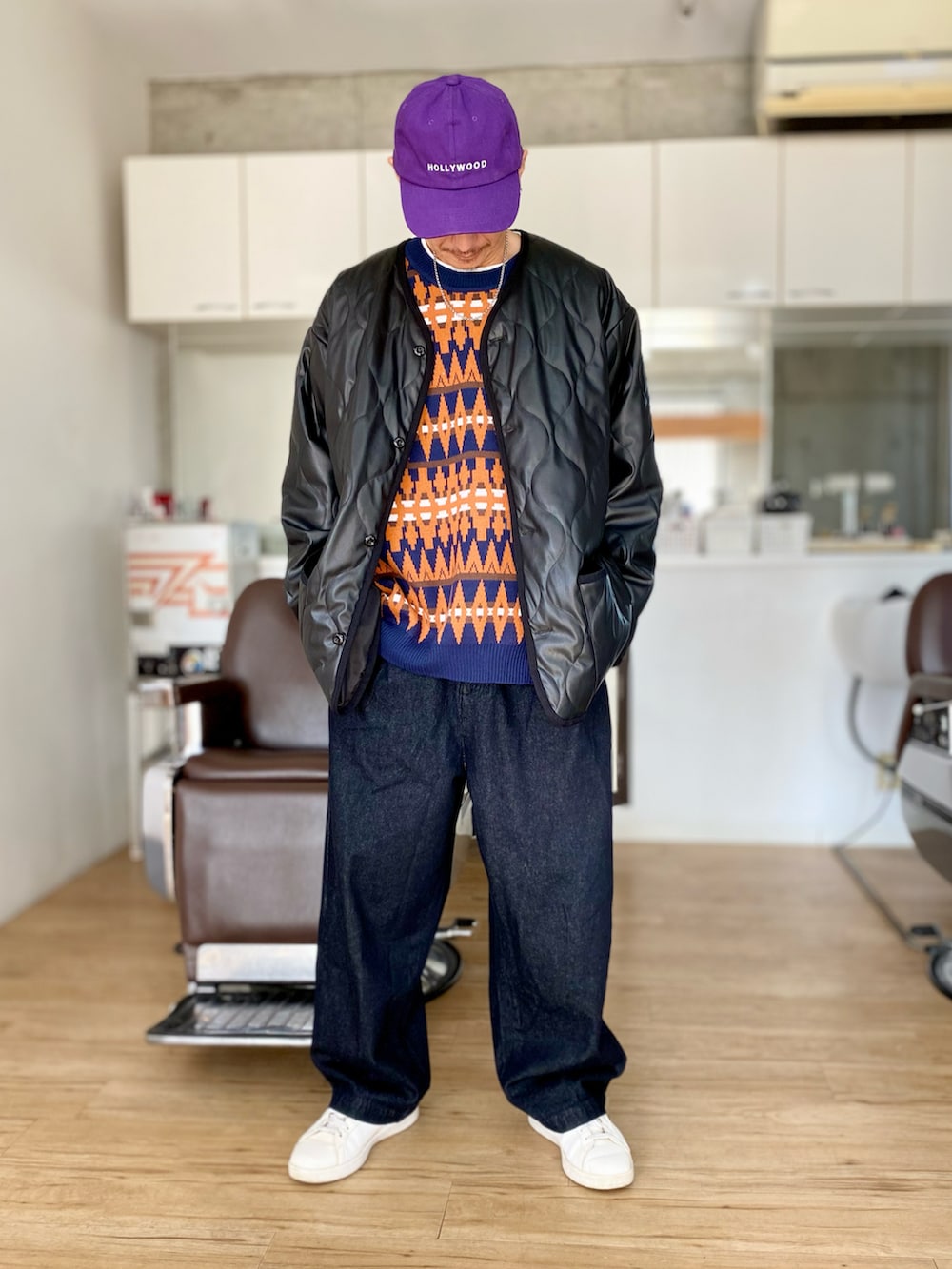 ブラック系のデニムパンツ、ブルー系のベスト、ブラック系のダウンジャケット/コートを着用したメンズの冬コーディネートの2枚目の写真