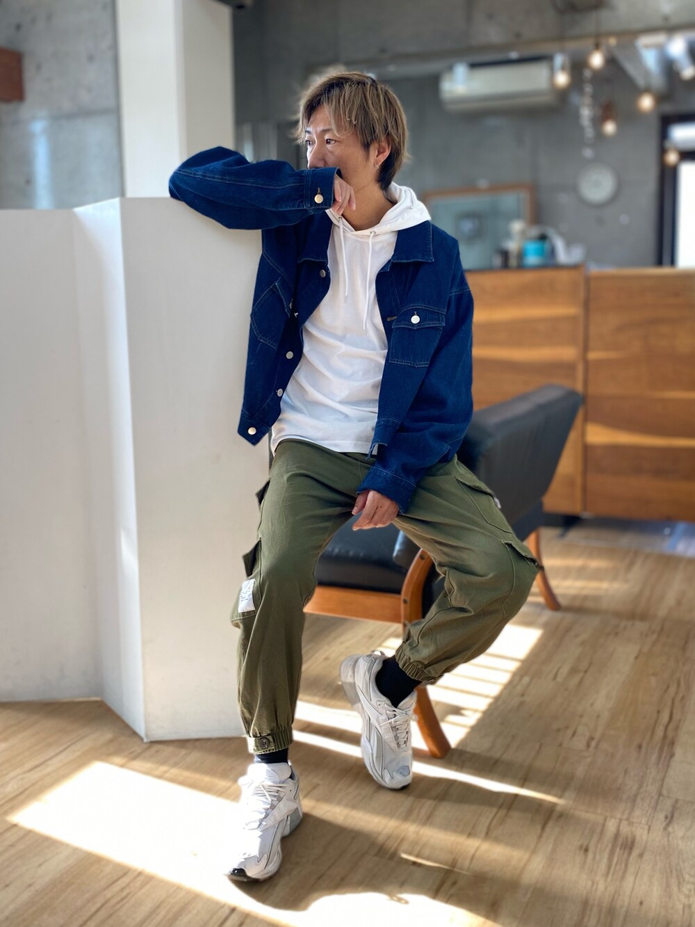 グリーン系のカーゴパンツ、ブルー系のデニムジャケット、ホワイト系のスニーカーを着用したメンズの秋コーディネートの2枚目の写真