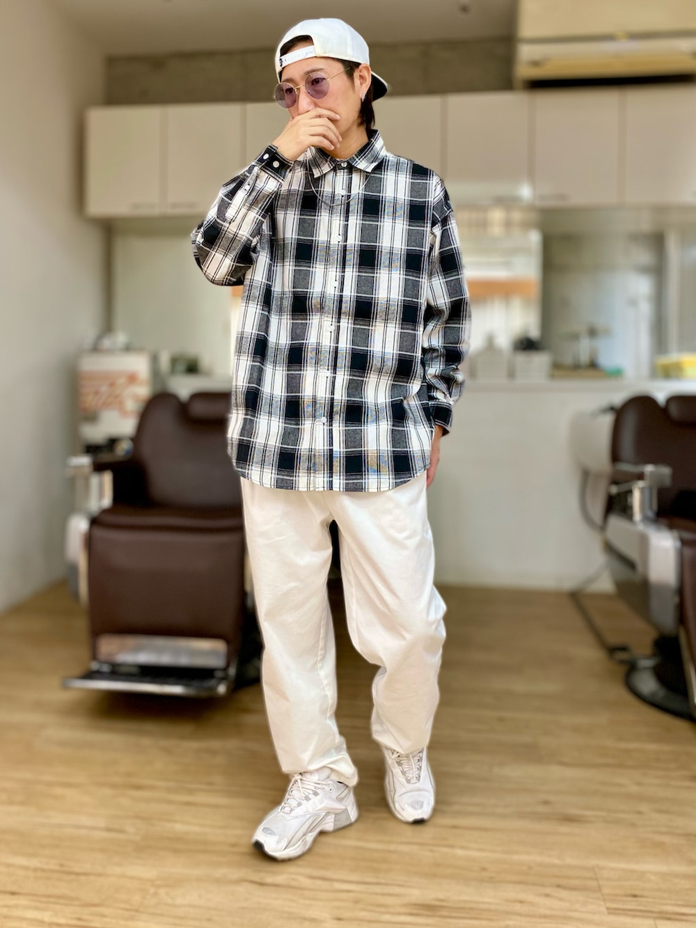 ホワイト系のチノパンツ、ホワイト系のスニーカー、ブラック系のシャツ/ブラウスを着用したメンズの春コーディネートの2枚目の写真