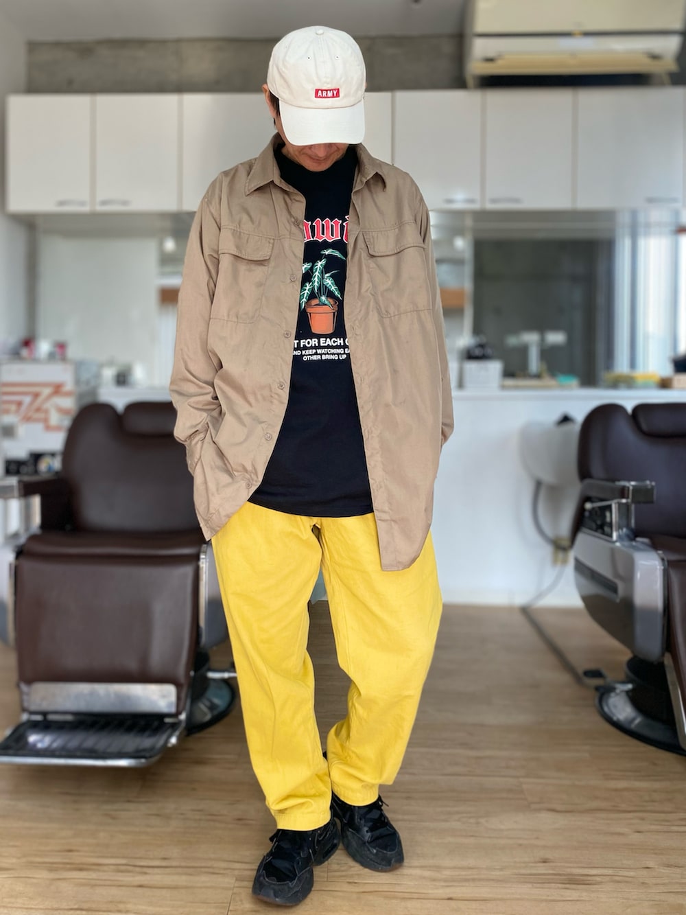 イエロー系のその他パンツ、ブラック系のスニーカー、ブラック系のTシャツ/カットソーを着用したメンズの春コーディネートの2枚目の写真