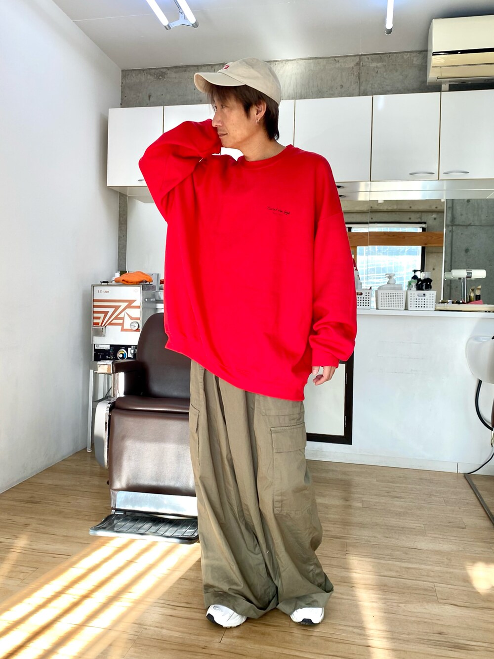 グリーン系のカーゴパンツ、レッド系のスウェット、ホワイト系のスニーカーを着用したメンズの冬コーディネートの2枚目の写真