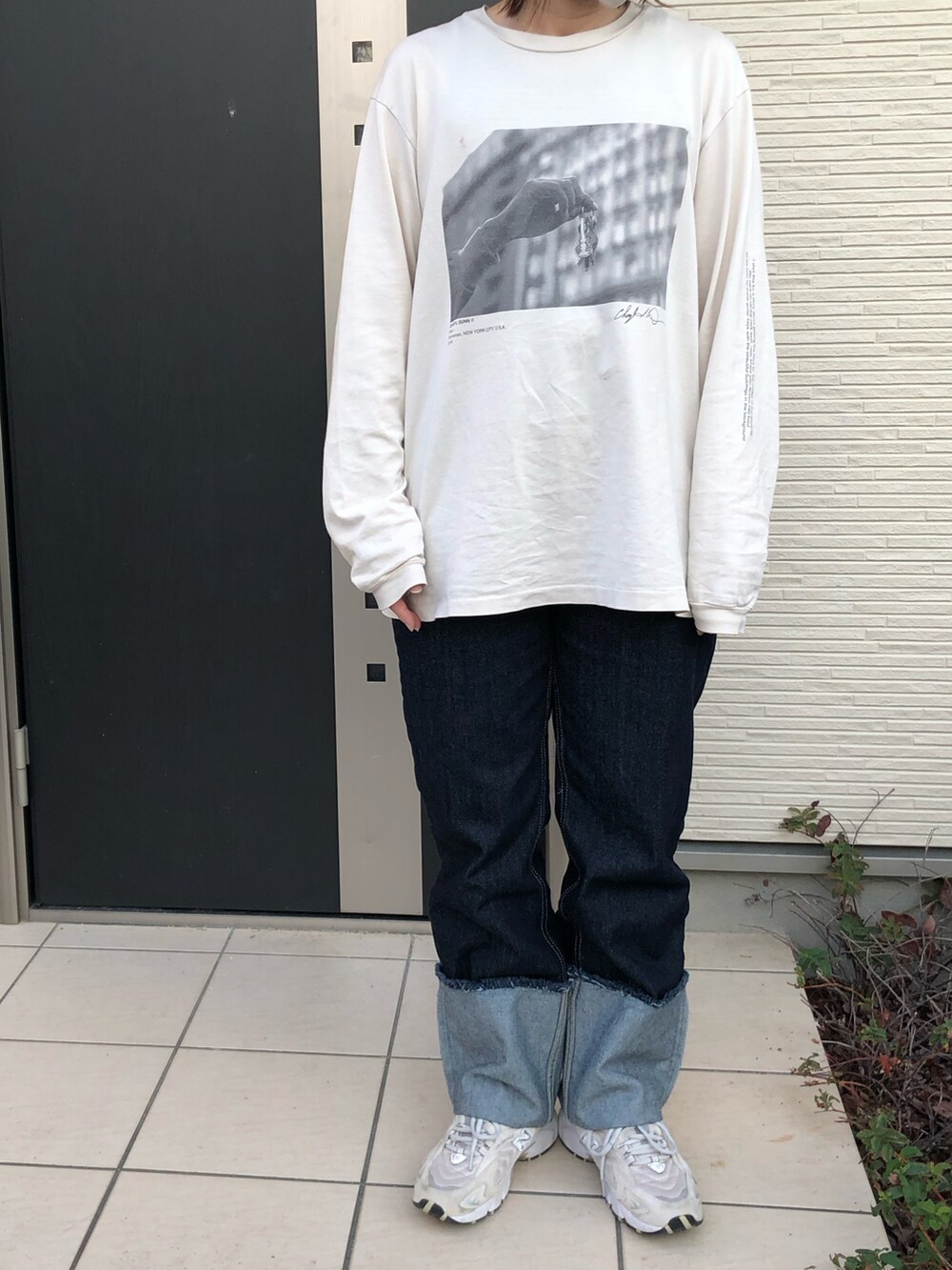 ベージュ系のTシャツ/カットソー、ブルー系のデニムパンツ、ベージュ系のスニーカーを着用したレディースの秋コーディネートの2枚目の写真
