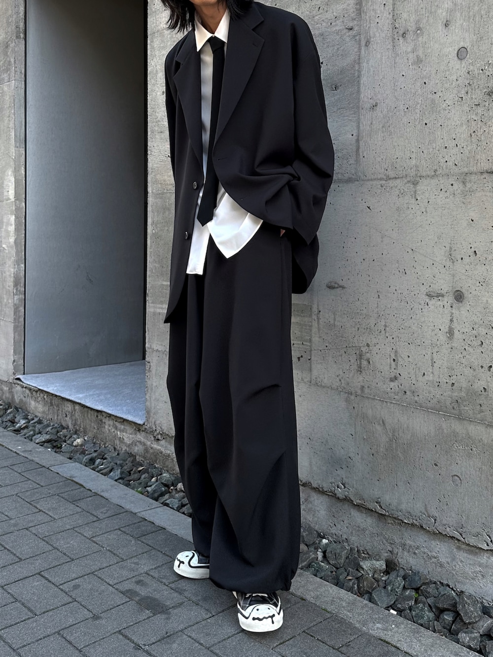 ブラック系のその他パンツ、ブラック系のスニーカー、ホワイト系のシャツ/ブラウスを着用したメンズの春コーディネートの5枚目の写真