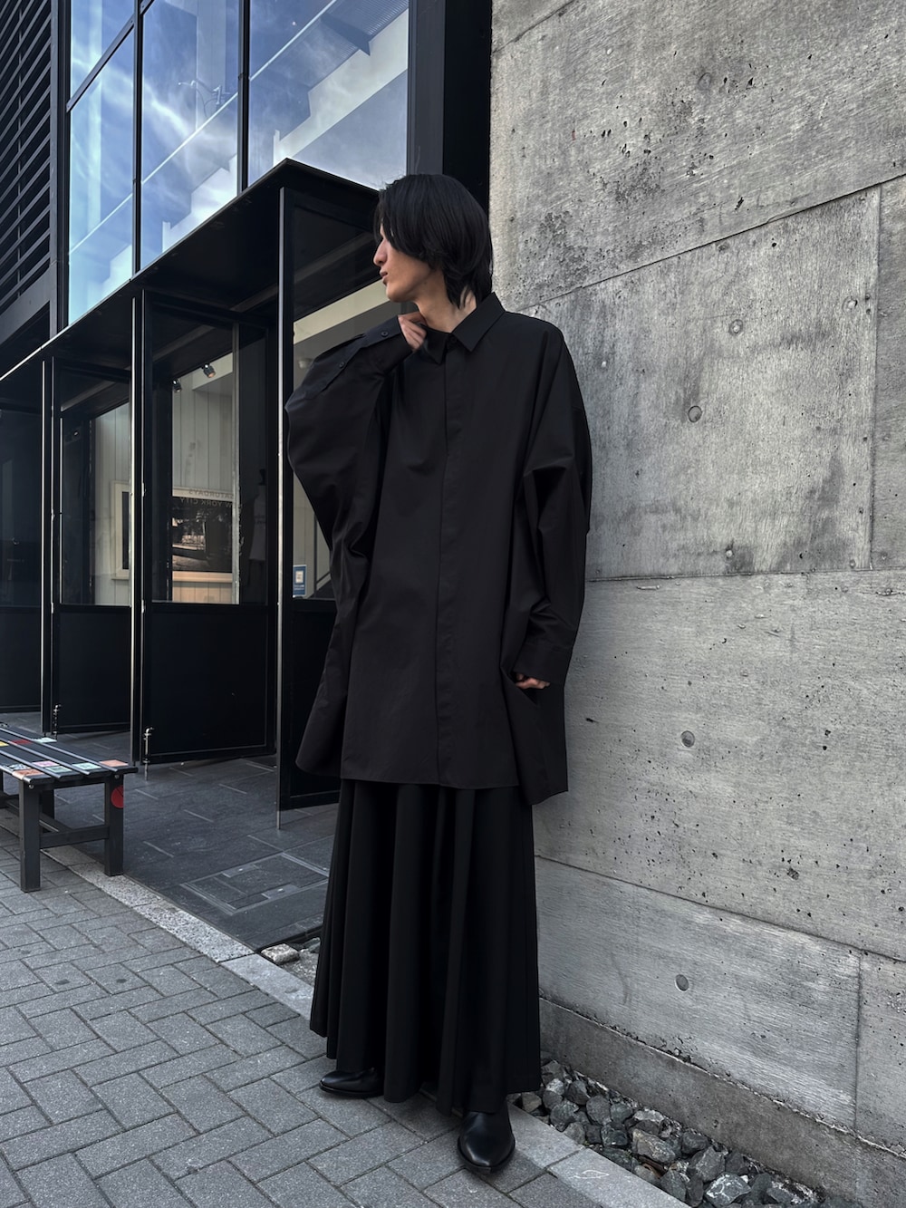 ブラック系のスラックス、ブラック系のブーツ、ブラック系のTシャツ/カットソーを着用したメンズの春コーディネートの4枚目の写真