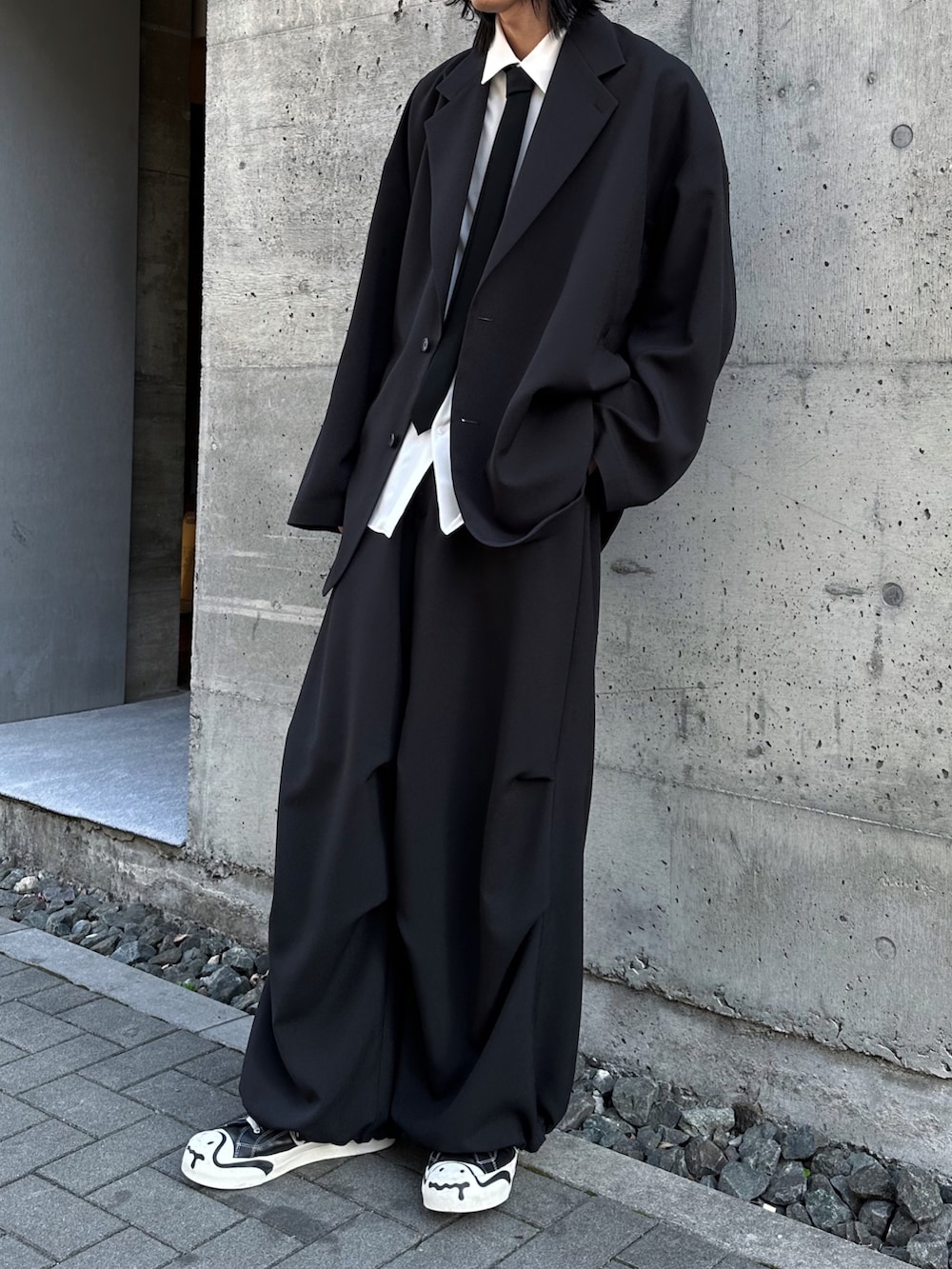 ブラック系のその他パンツ、ブラック系のスニーカー、ホワイト系のシャツ/ブラウスを着用したメンズの春コーディネートの2枚目の写真