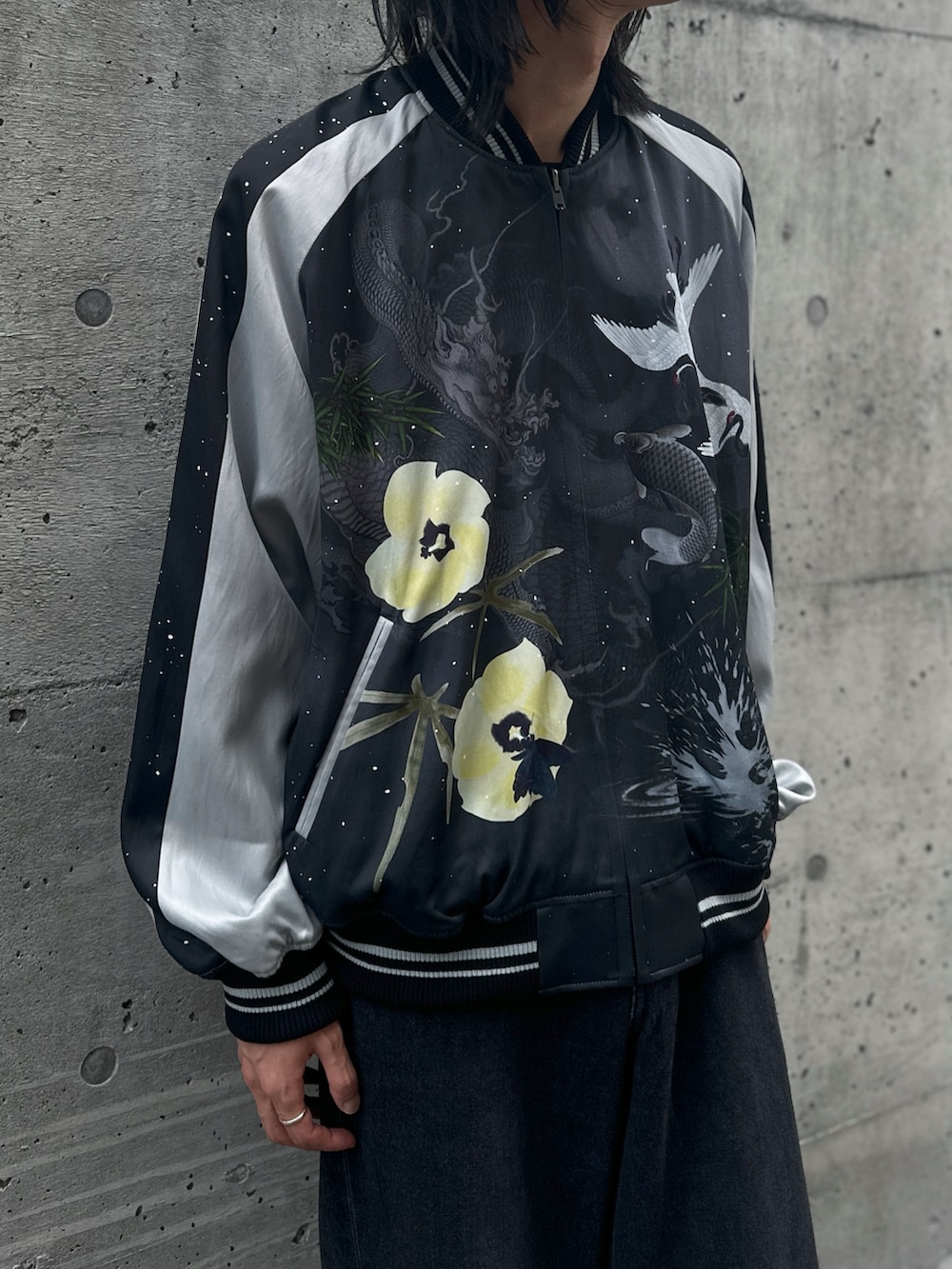 ブラック系のローファー、ブラック系のスカジャン、グレー系のデニムパンツを着用したメンズの秋コーディネートの2枚目の写真