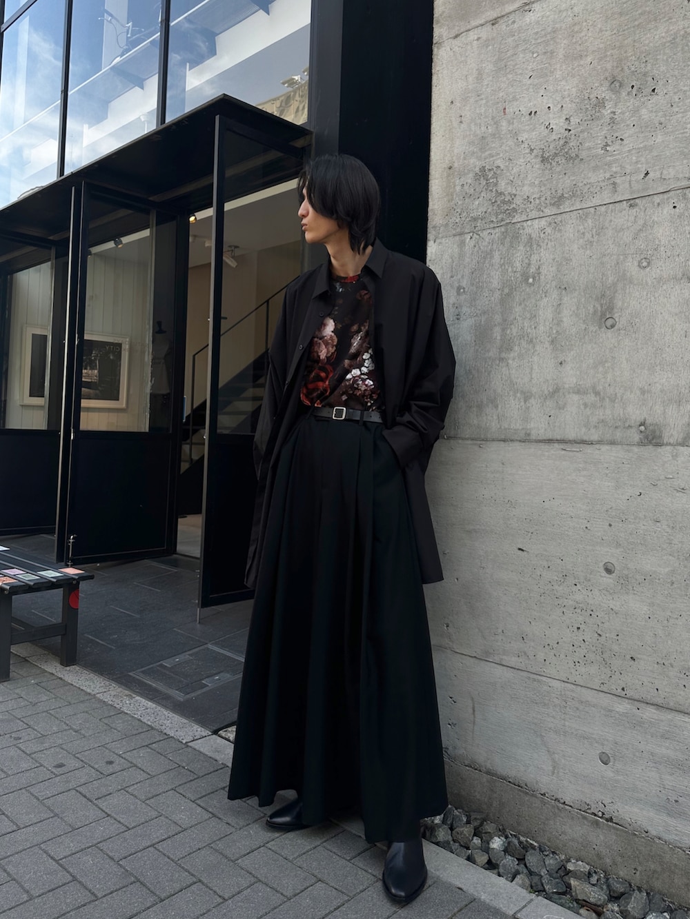 ブラック系のスラックス、ブラック系のブーツ、ブラック系のTシャツ/カットソーを着用したメンズの春コーディネートの3枚目の写真