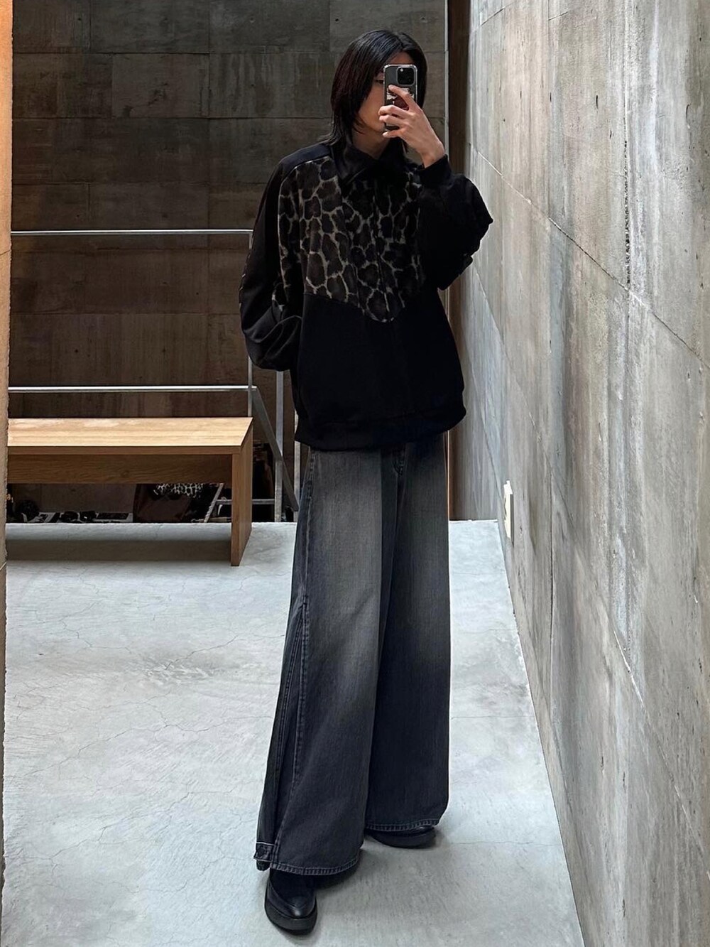 グレー系のデニムパンツ、ブラック系のドレスシューズ、ブラック系のジャージを着用したメンズの春コーディネートの2枚目の写真