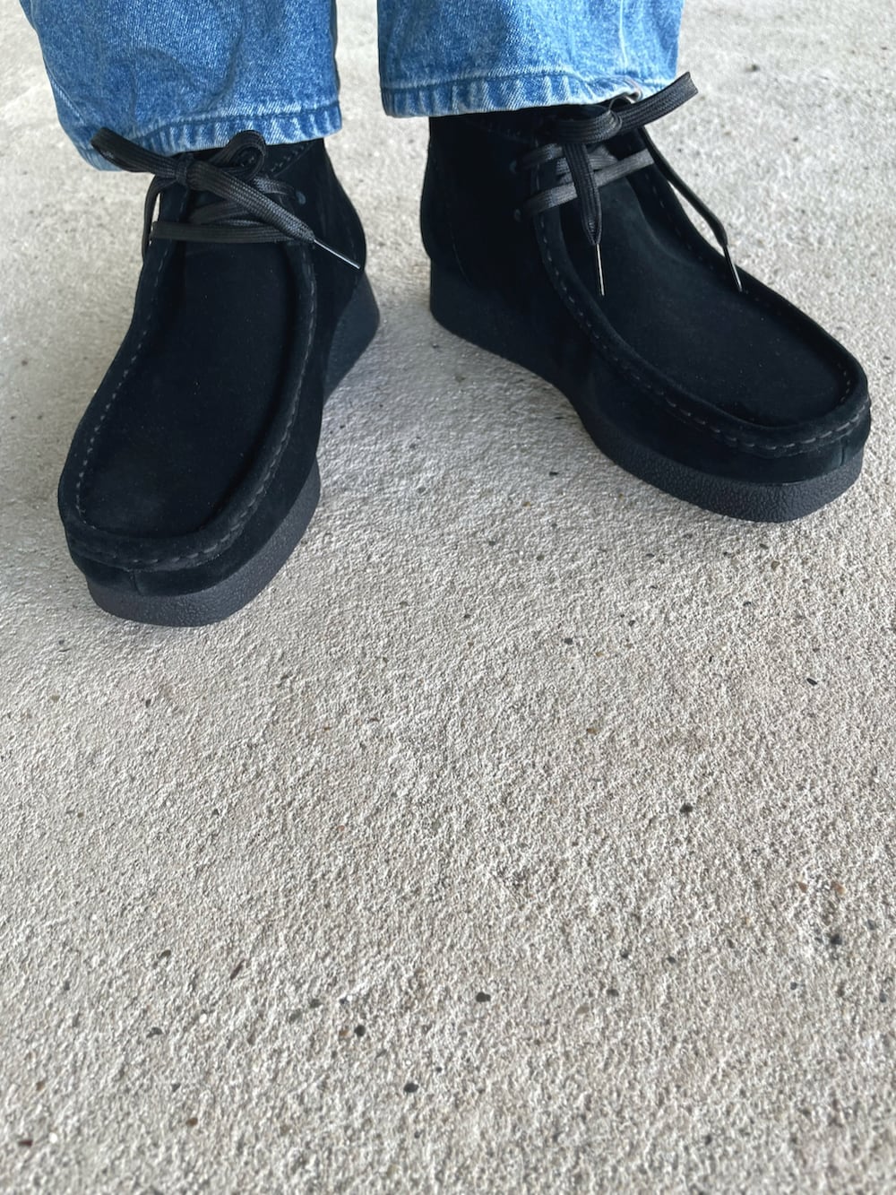 グリーン系のワンピース、ブラック系のモカシン/デッキシューズ、ブルー系のデニムパンツを着用したレディースの秋コーディネートの2枚目の写真