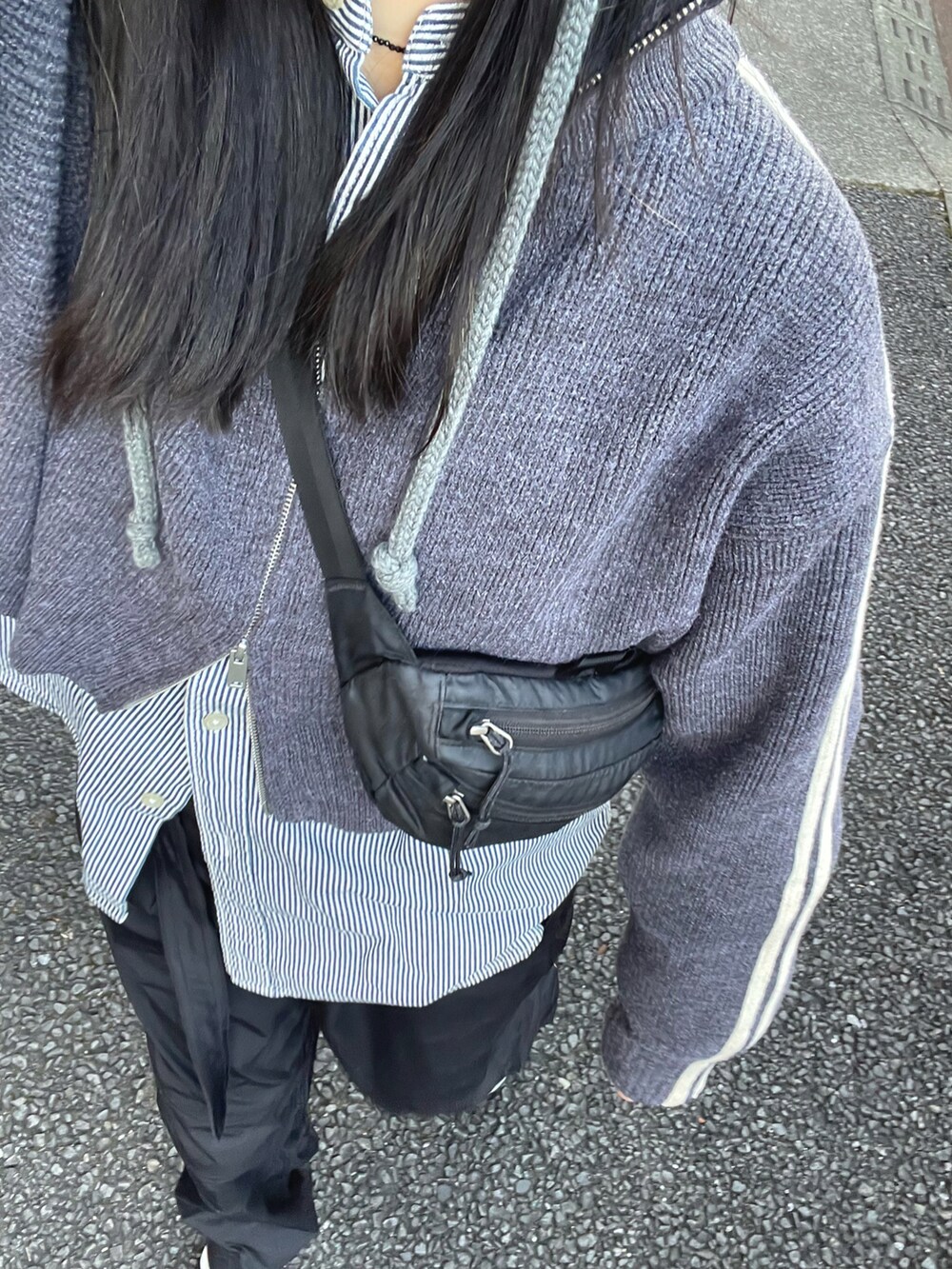 グレー系のニット/セーター、ホワイト系のスニーカー、グレー系のニットキャップ/ビーニーを着用したレディースの冬コーディネートの3枚目の写真