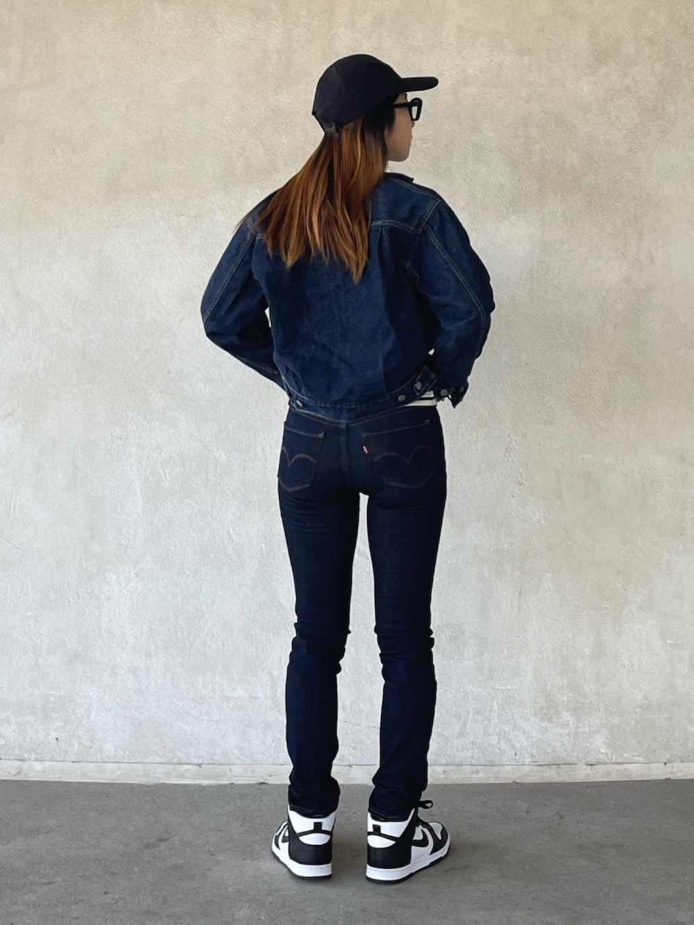 ブルー系のデニムパンツ、ホワイト系のスニーカーを着用したレディースの春コーディネートの2枚目の写真