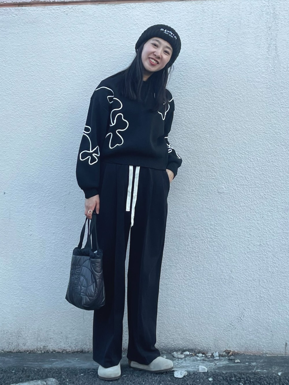 ブラック系のニット/セーター、ブラック系のスウェットパンツ、ベージュ系のサンダルを着用したレディースの冬コーディネートの3枚目の写真