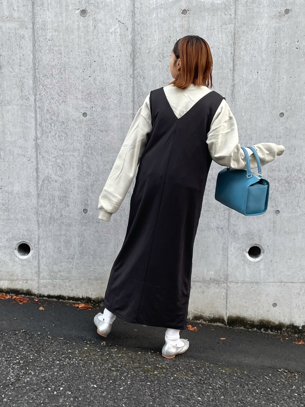 ベージュ系のスウェット、ブラック系のジャンパースカート、シルバー系のバレエシューズを着用したレディースの冬コーディネートの4枚目の写真