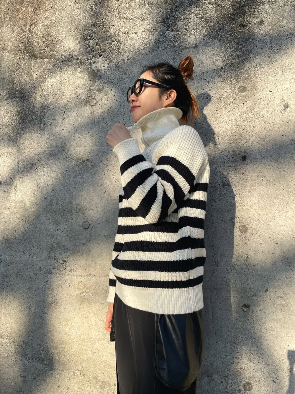 グリーン系のMA-1、ホワイト系のニット/セーター、ブラック系のその他パンツを着用したレディースの冬コーディネートの4枚目の写真