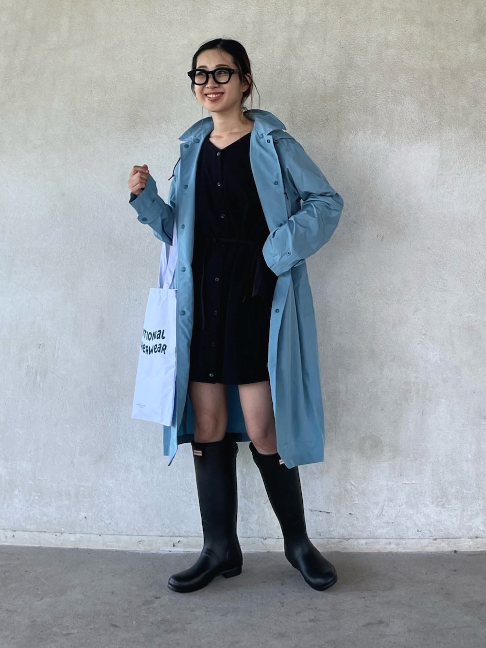 ホワイト系のトートバッグ、その他のチュニック、ブラック系のレインシューズを着用したレディースの春コーディネートの2枚目の写真