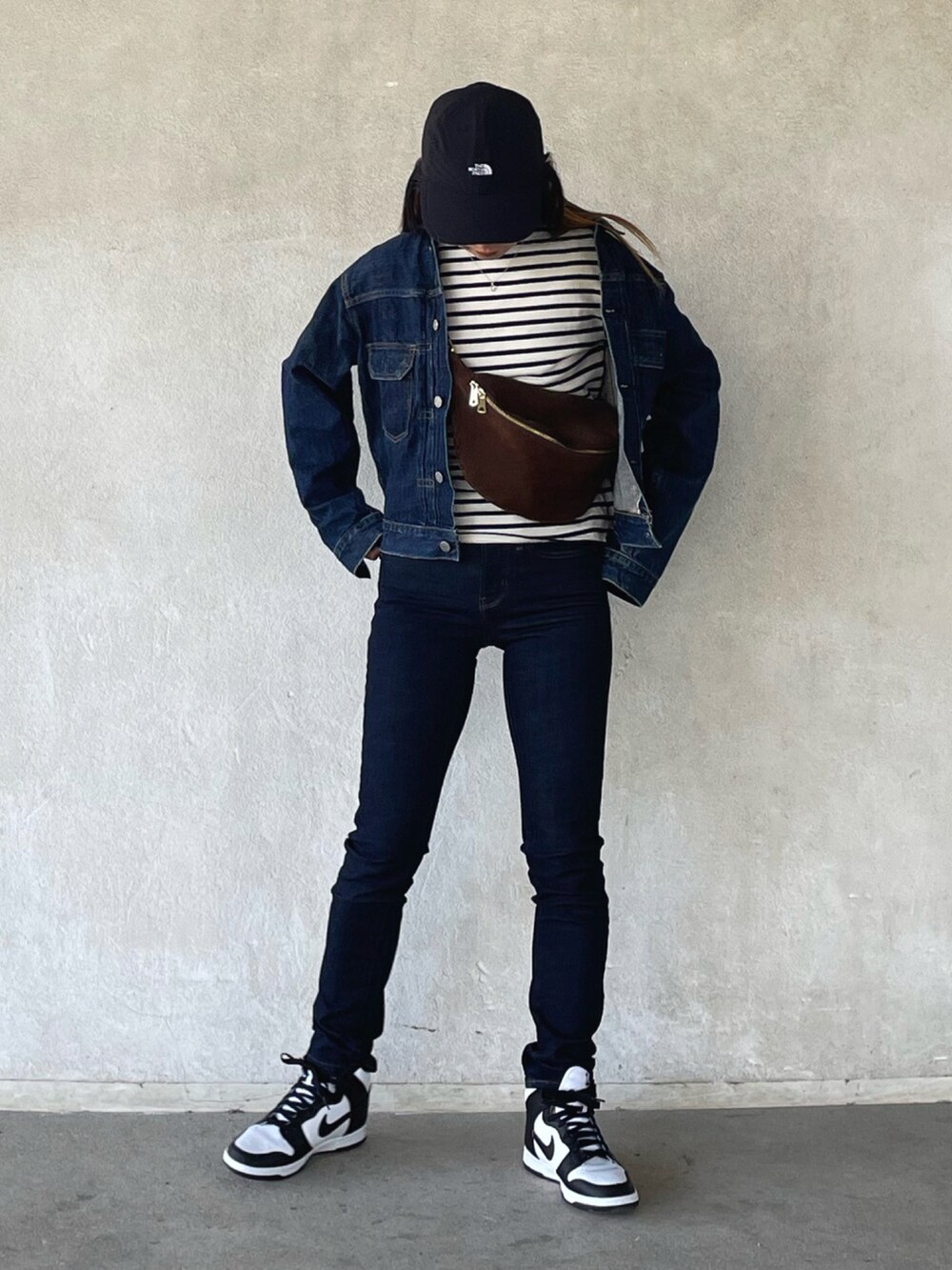 ブルー系のデニムパンツ、ホワイト系のスニーカーを着用したレディースの春コーディネートの5枚目の写真