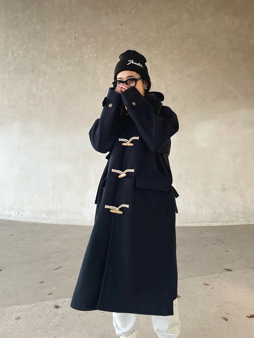 ブルー系のダッフルコート、グレー系のスウェットパンツ、グリーン系のスニーカーを着用したレディースの冬コーディネートの3枚目の写真