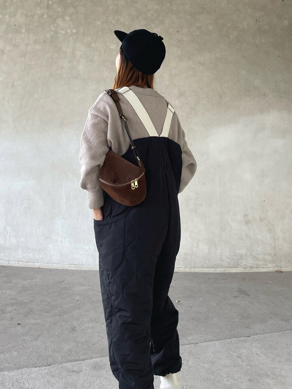 ベージュ系のニット/セーター、ブラック系のサロペット/オーバーオール、ベージュ系のブーツを着用したレディースの秋コーディネートの5枚目の写真