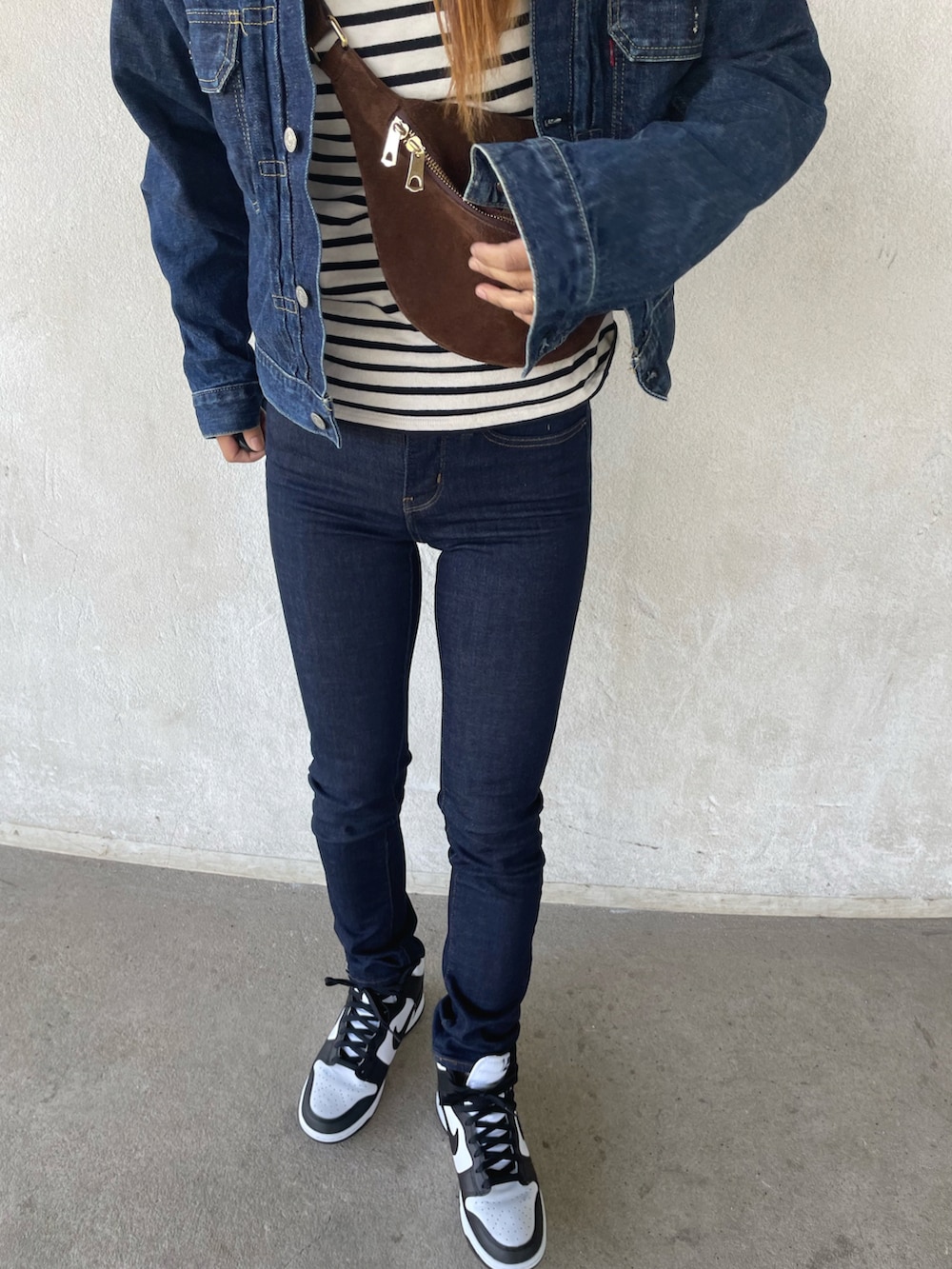 ブルー系のデニムパンツ、ホワイト系のスニーカーを着用したレディースの春コーディネートの3枚目の写真